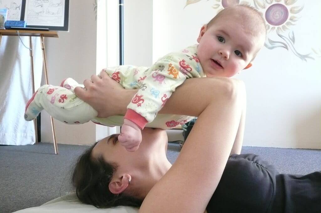 Photographie d'un groupe de cours de yoga avec bébé